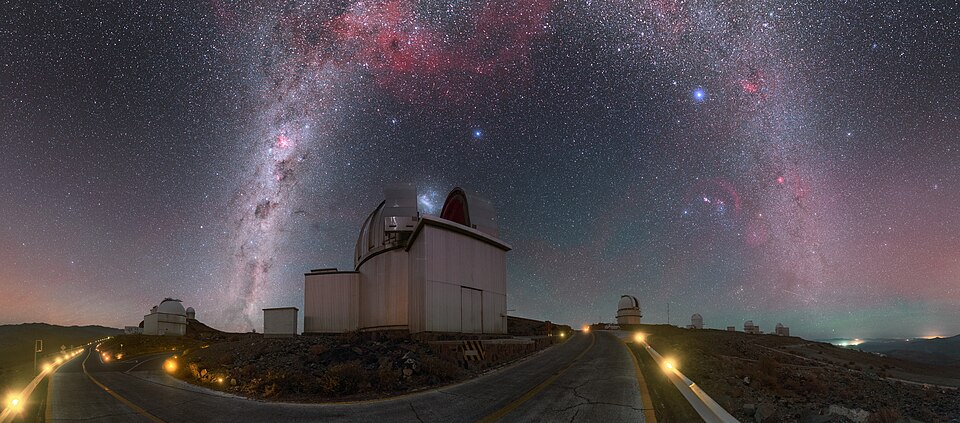 The Milky Way arching over the telescope domes of a dark-sky observatory site